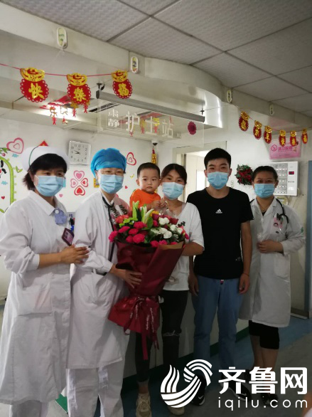 刘心洁主任与王玉珍护士长手持锦旗合影患儿及父母与医护合影
